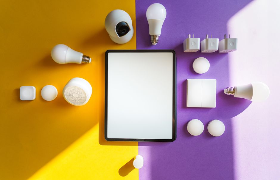 Dispositivos de hogar inteligente y tablet sobre fondo amarillo y morado